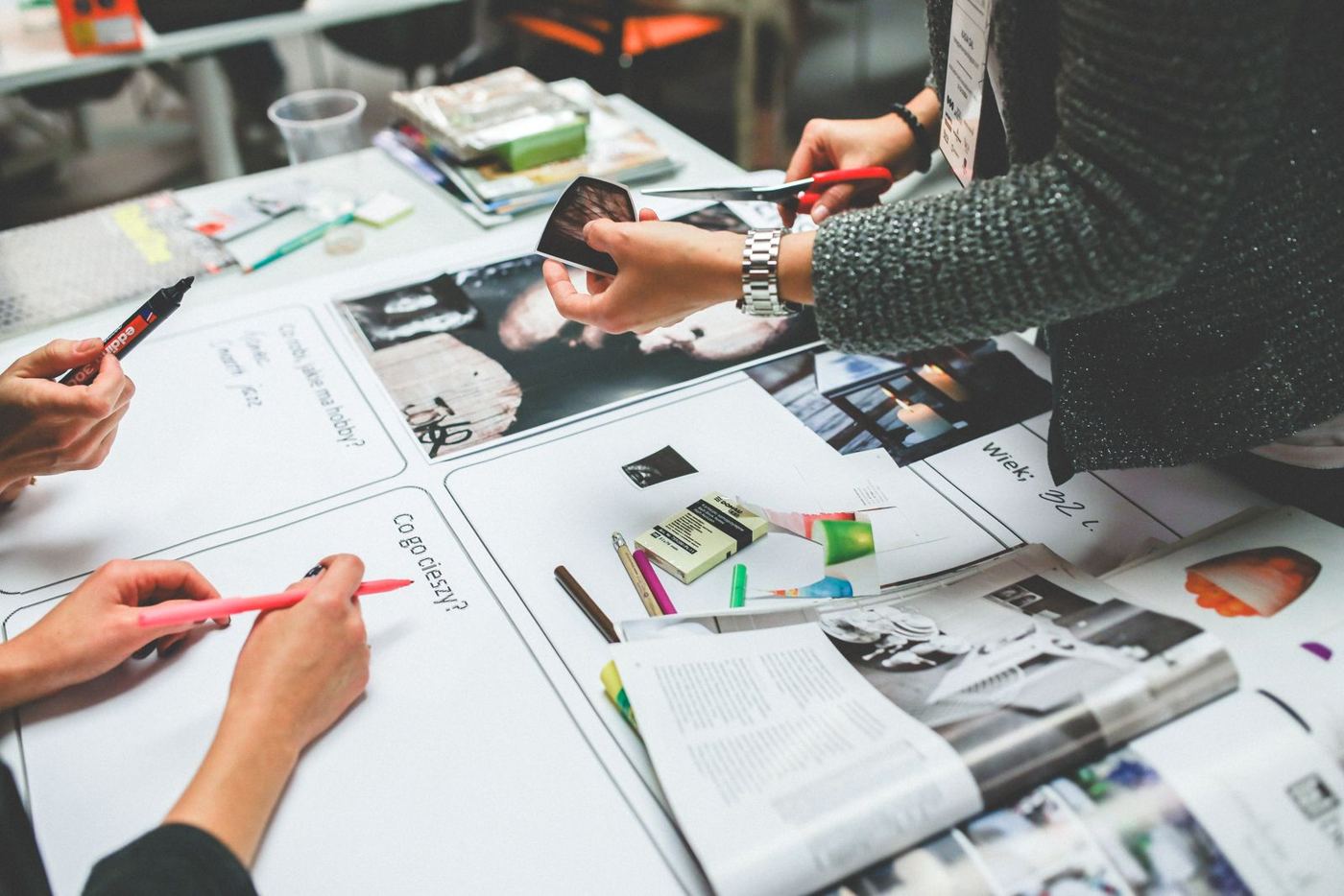Manos trabajando sobre bocetos y piezas impresas de diseño